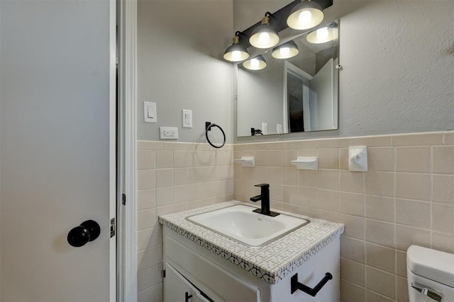 bathroom featuring vanity, toilet, and tile walls