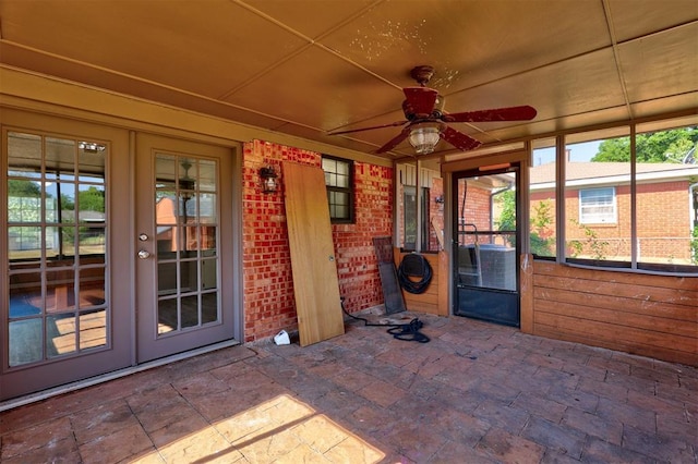 unfurnished sunroom with ceiling fan and french doors