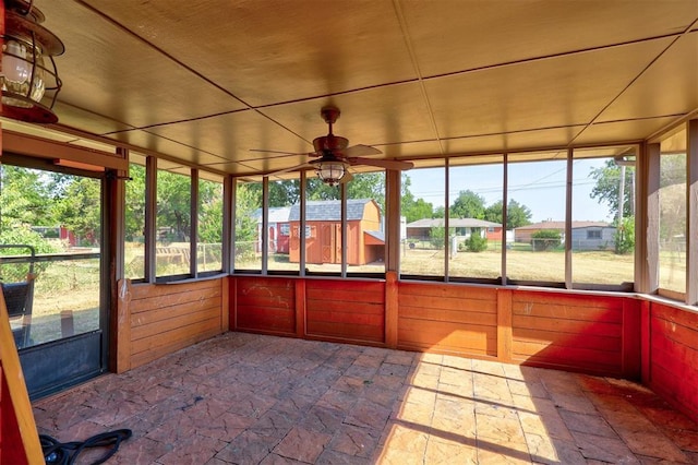 unfurnished sunroom featuring ceiling fan