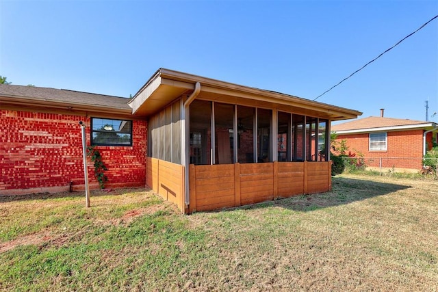 exterior space featuring a lawn and a sunroom