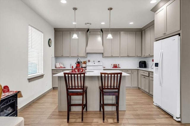 1305 Katelyn Ct, Yukon, OK 73099 - kitchen with white appliances, custom exhaust hood, gray cabinets, light wood-style flooring, and recessed lighting