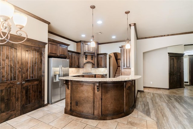 kitchen with ornamental molding, backsplash, hanging light fixtures, dark brown cabinetry, and stainless steel refrigerator with ice dispenser