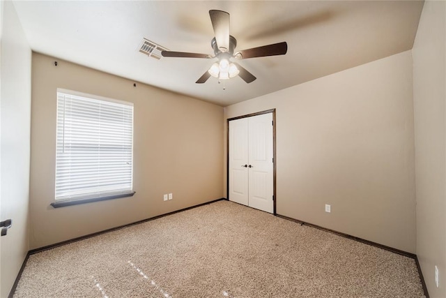 carpeted spare room featuring ceiling fan and a wealth of natural light