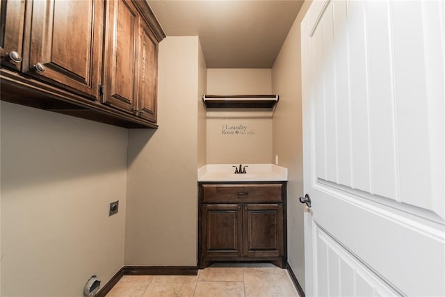 clothes washing area with sink, cabinets, electric dryer hookup, and light tile patterned floors