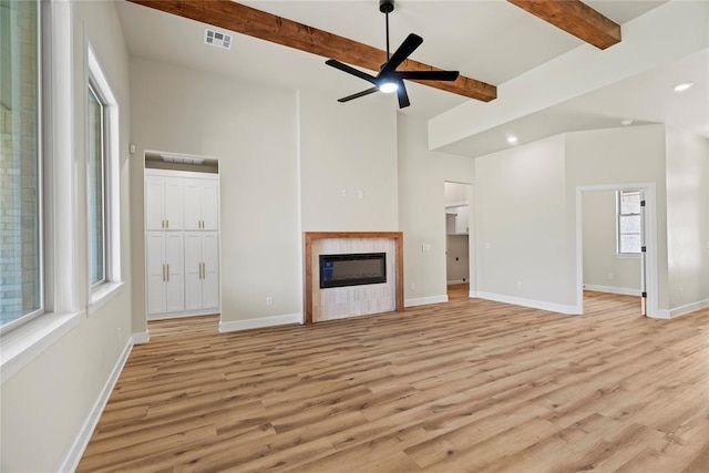 unfurnished living room with beam ceiling, light hardwood / wood-style floors, and ceiling fan