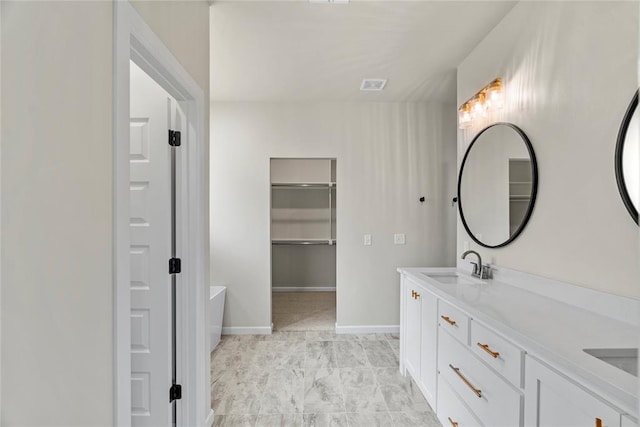 bathroom featuring vanity and a washtub