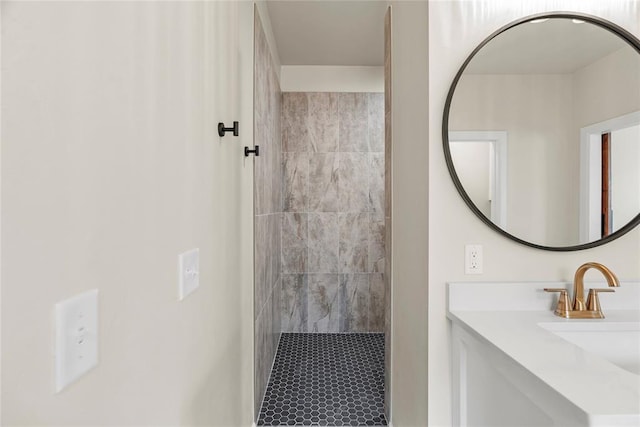 bathroom with a tile shower and vanity