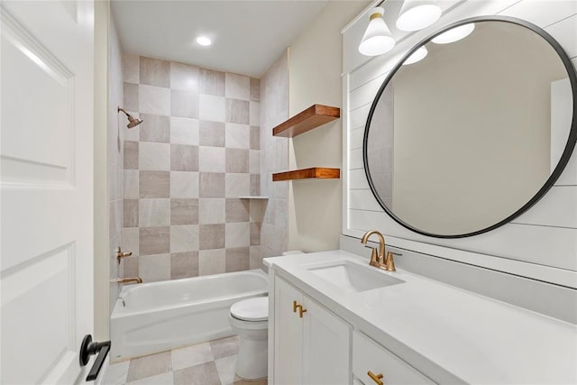 full bathroom featuring vanity, tiled shower / bath combo, and toilet