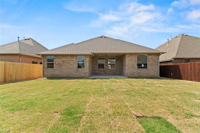 rear view of house featuring a lawn and a patio area