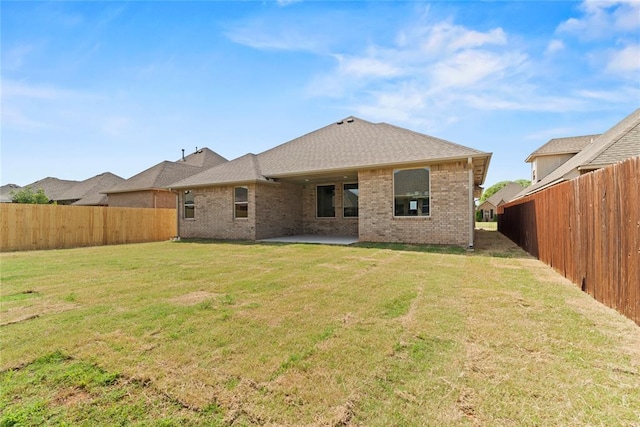 back of house with a yard and a patio