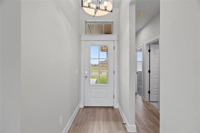 entryway featuring light hardwood / wood-style flooring and a chandelier