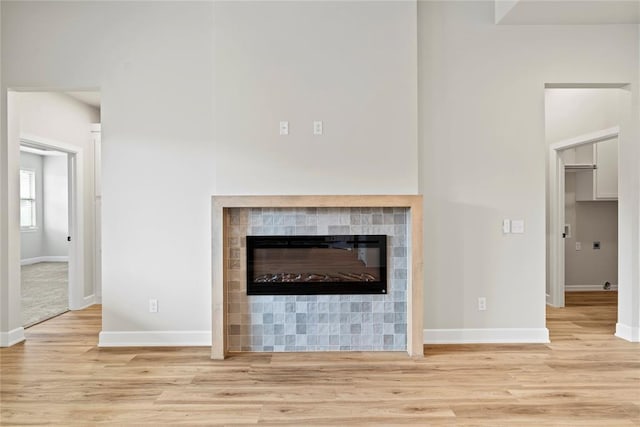 interior details featuring a tile fireplace and wood-type flooring