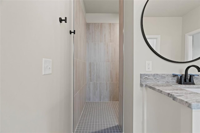 bathroom featuring vanity and tiled shower