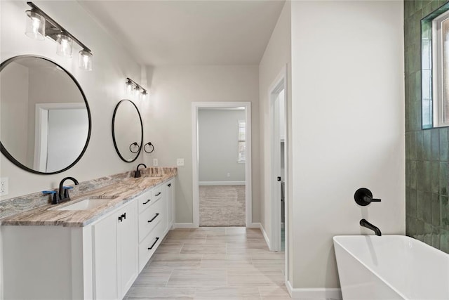 bathroom featuring tile patterned floors, vanity, and a bath