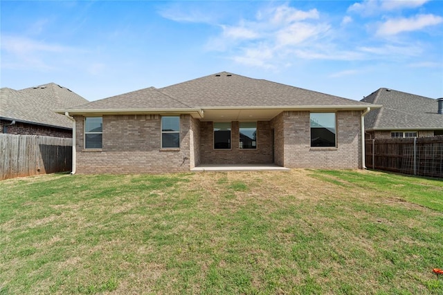 back of house with a patio area and a lawn