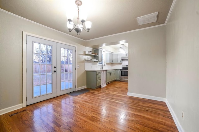 interior space with ornamental molding, light hardwood / wood-style flooring, and french doors