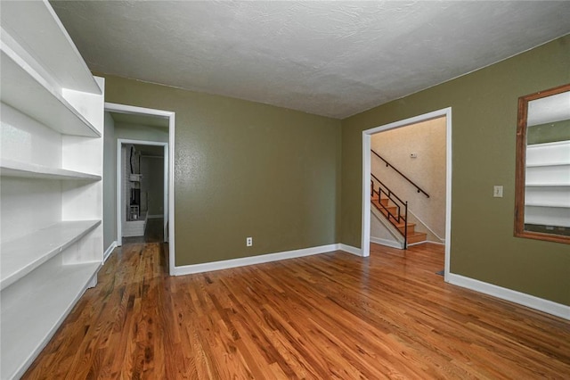 empty room with hardwood / wood-style flooring and a textured ceiling