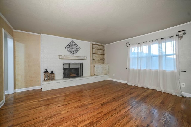 unfurnished living room with crown molding, a brick fireplace, and dark wood-type flooring