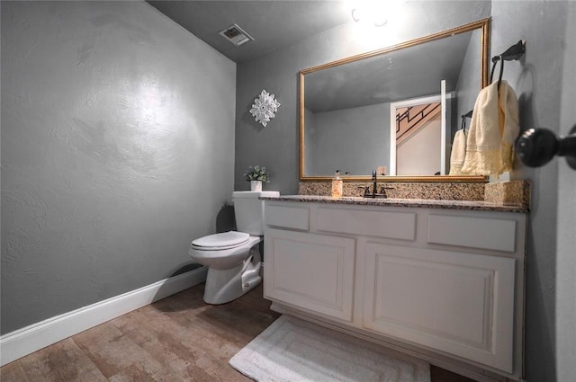 bathroom with vanity, hardwood / wood-style floors, and toilet