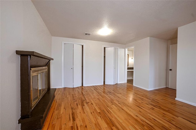 unfurnished living room with hardwood / wood-style flooring and a textured ceiling