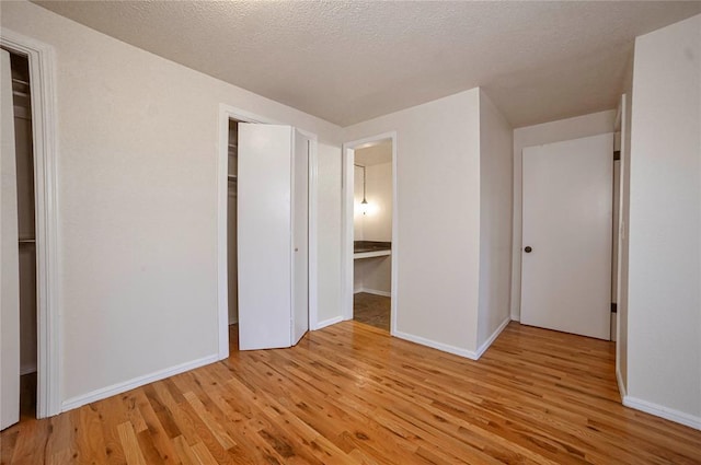 unfurnished bedroom with light hardwood / wood-style floors and a textured ceiling