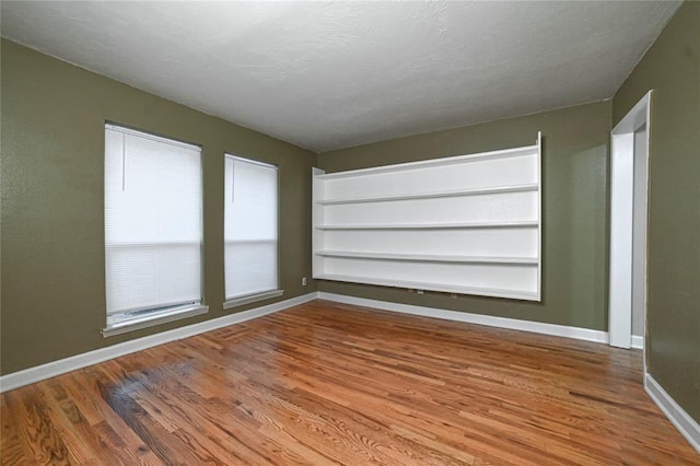 unfurnished room featuring hardwood / wood-style flooring and a textured ceiling