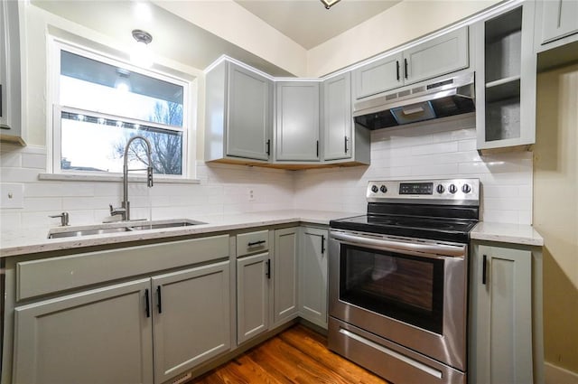 kitchen featuring gray cabinetry, sink, light stone counters, and stainless steel electric range oven