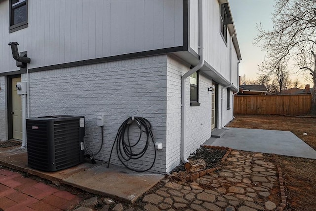 property exterior at dusk featuring cooling unit