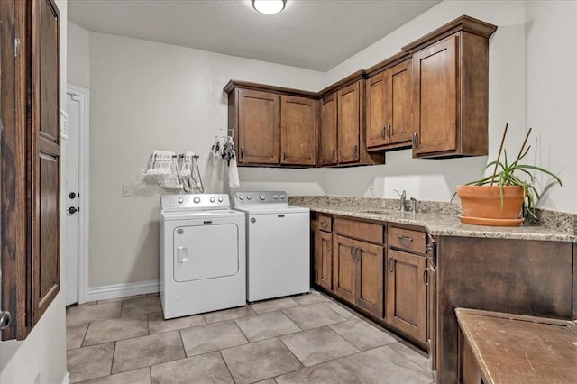 laundry area featuring cabinets, washer and clothes dryer, and sink