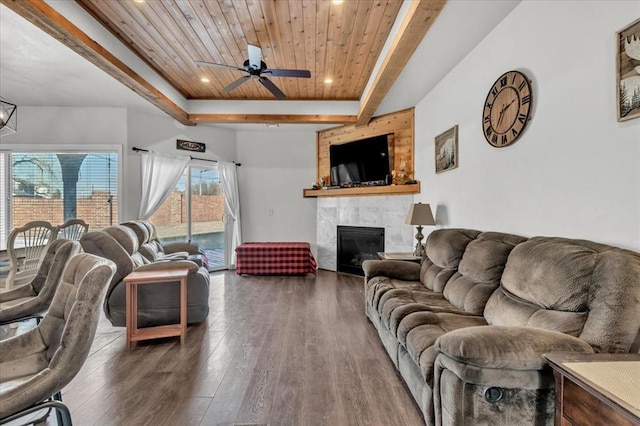 living area with wooden ceiling, wood finished floors, a ceiling fan, a tiled fireplace, and a raised ceiling