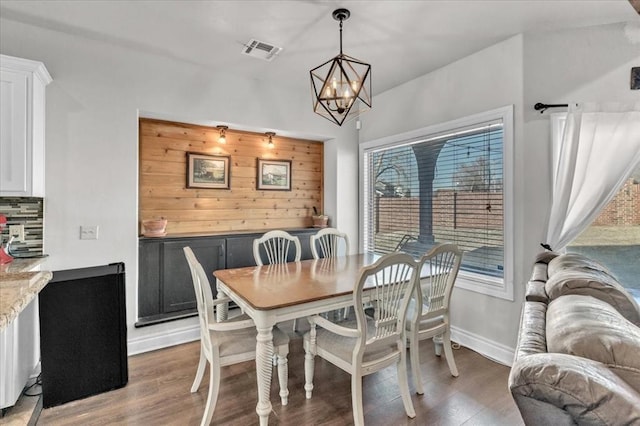 dining room featuring an inviting chandelier, light wood-style flooring, visible vents, and baseboards