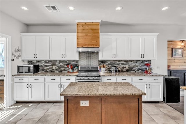 kitchen with white cabinetry, visible vents, stainless steel appliances, and decorative backsplash