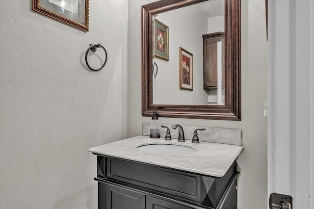 bathroom featuring a textured wall and vanity