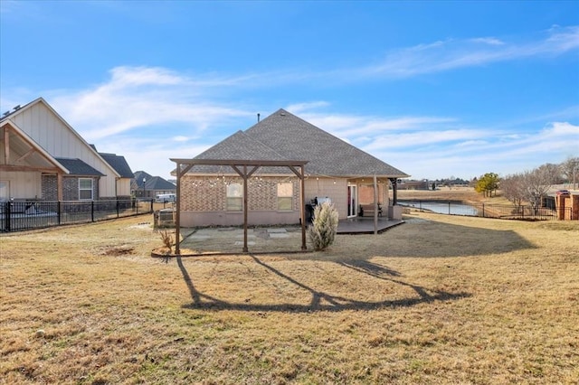 back of house featuring a patio, a yard, roof with shingles, and fence