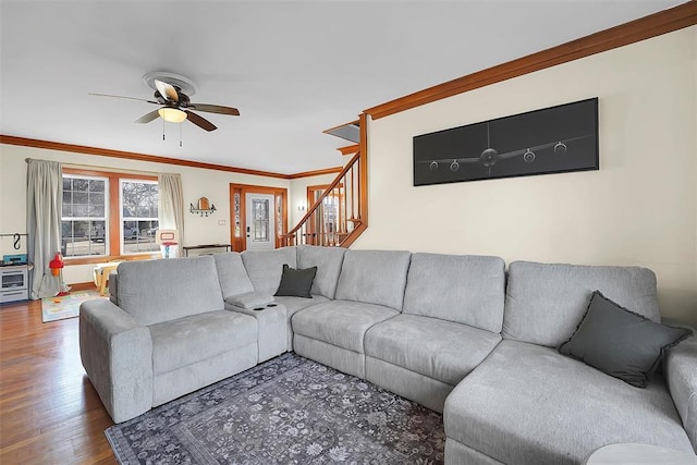 living room featuring hardwood / wood-style flooring, ornamental molding, and ceiling fan