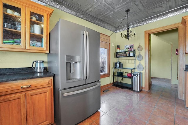 kitchen featuring tile patterned flooring, stainless steel refrigerator with ice dispenser, and decorative light fixtures