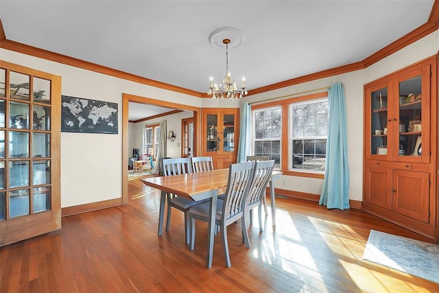 dining room featuring an inviting chandelier, ornamental molding, and wood-type flooring