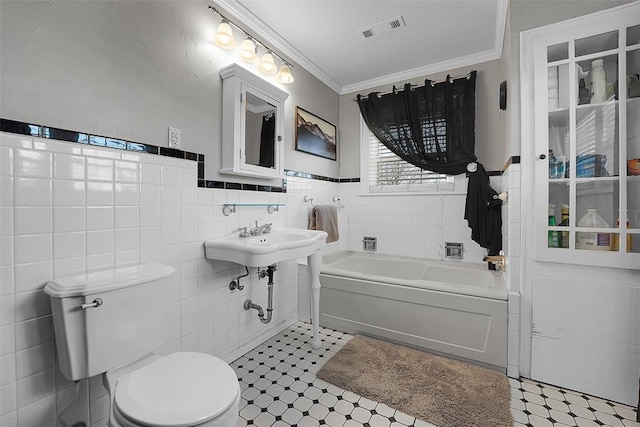 bathroom featuring crown molding, a bath, toilet, and tile walls