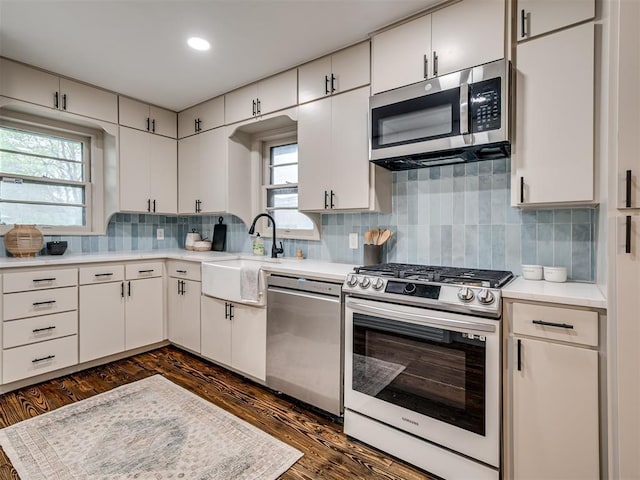 kitchen featuring tasteful backsplash, white cabinetry, sink, and stainless steel appliances