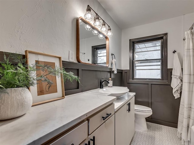 bathroom featuring toilet, vanity, tile patterned floors, and walk in shower