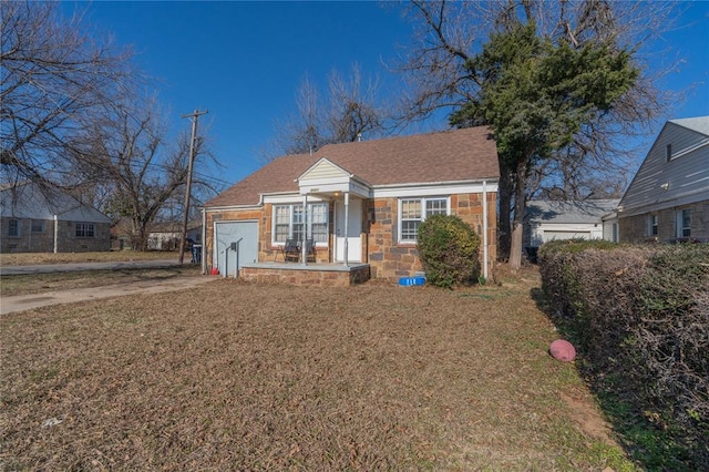 bungalow-style house featuring a garage and a front lawn