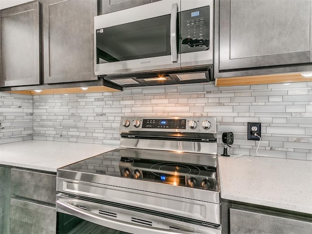 kitchen with appliances with stainless steel finishes and backsplash