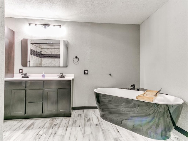 bathroom with wood-type flooring, separate shower and tub, a textured ceiling, and vanity