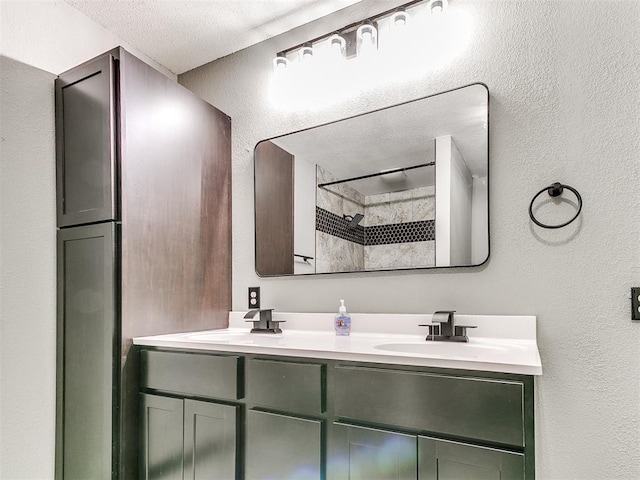 bathroom with vanity, a textured ceiling, and walk in shower