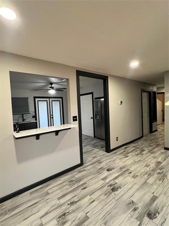 interior space featuring sink, a textured ceiling, light hardwood / wood-style floors, and ceiling fan