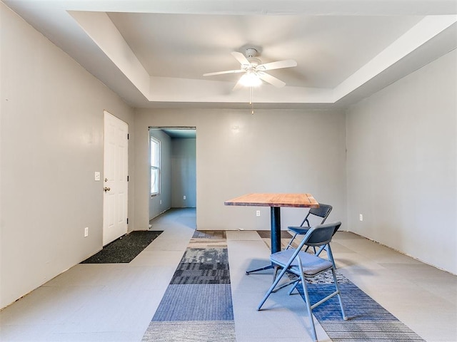 dining area with ceiling fan and a raised ceiling