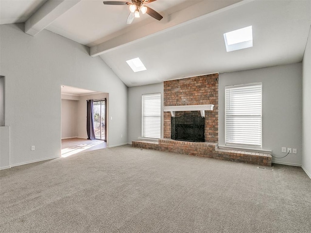 unfurnished living room with carpet flooring, a fireplace, ceiling fan, and a wealth of natural light