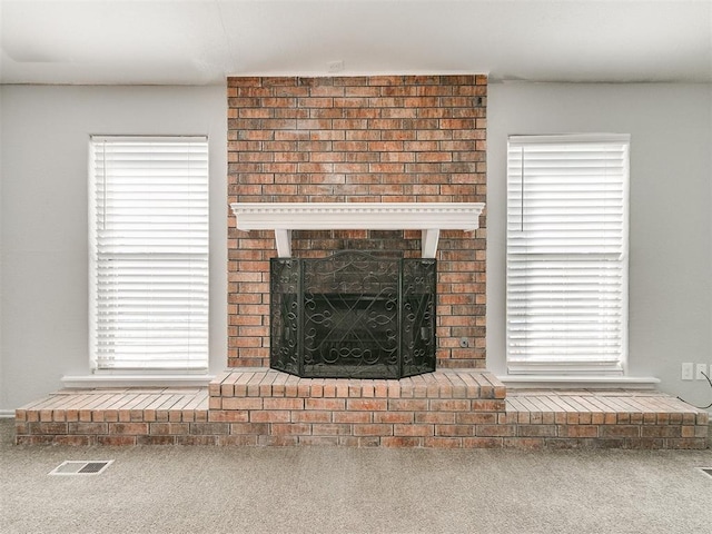 unfurnished living room featuring a wealth of natural light, carpet floors, and a fireplace