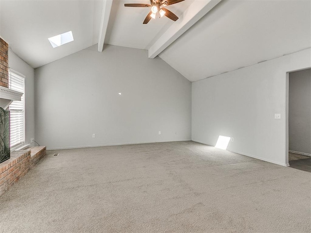 unfurnished living room featuring a brick fireplace, carpet floors, ceiling fan, and lofted ceiling with skylight