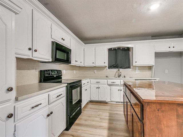 kitchen featuring black appliances, light hardwood / wood-style floors, sink, white cabinetry, and backsplash